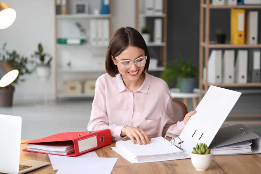 Young woman working with documents in office Przygotowywanie wniosków o dotacje