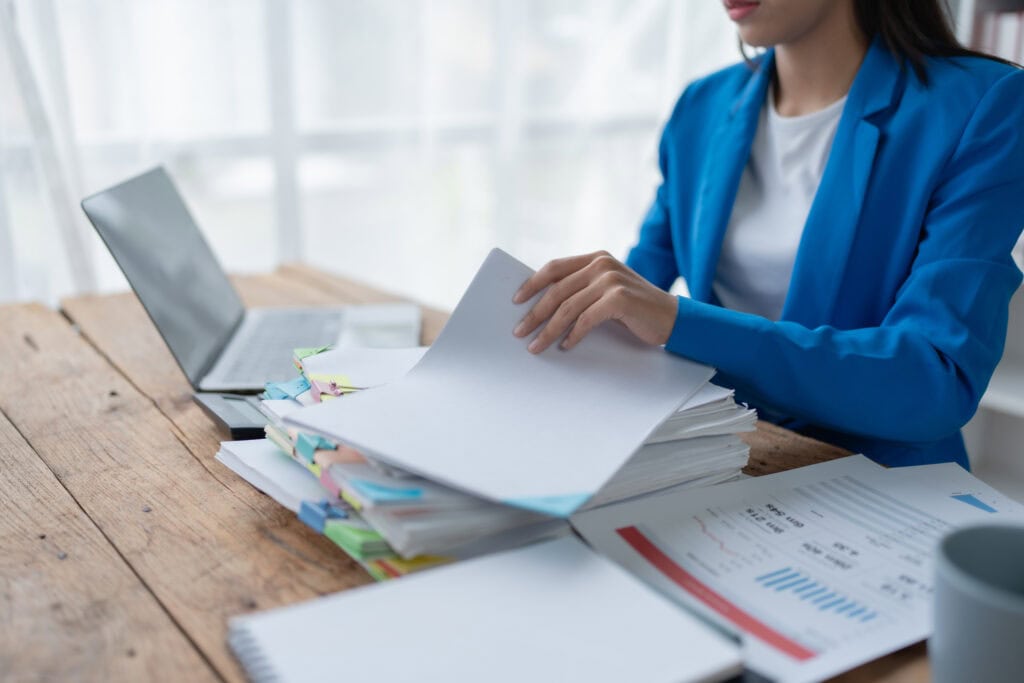 woman plans a finance and budget audit by reviewing organizing office financial documents